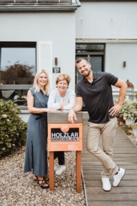 Holzlar-Team mit Verkaufsschild